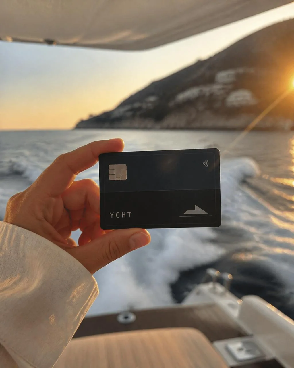 The YCHT card held on a boat at sunset