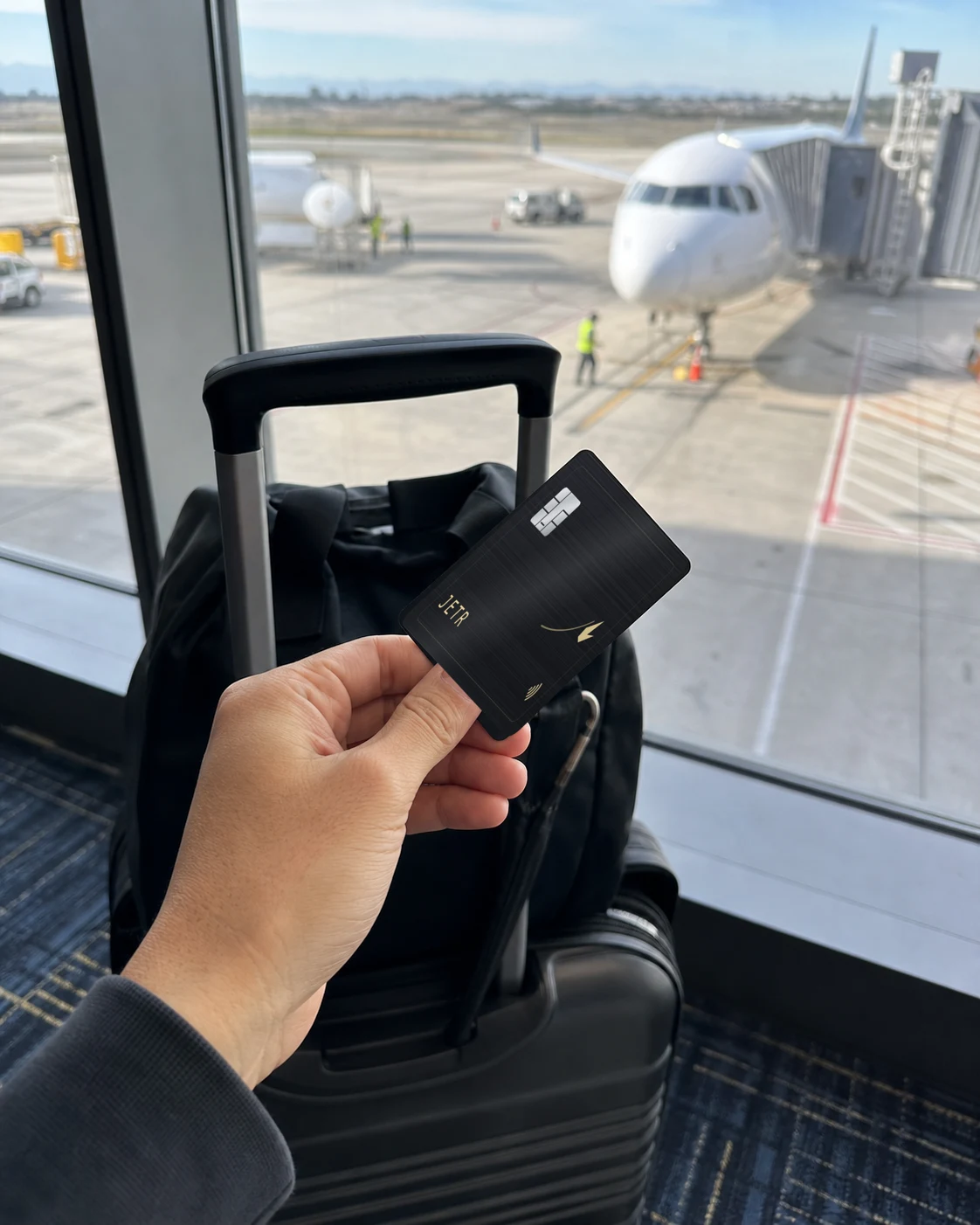 The JETR card held at the departure gate, a jet on stand behind the glass.